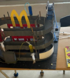 Student project, in shape of round car park with large yellow M on the top